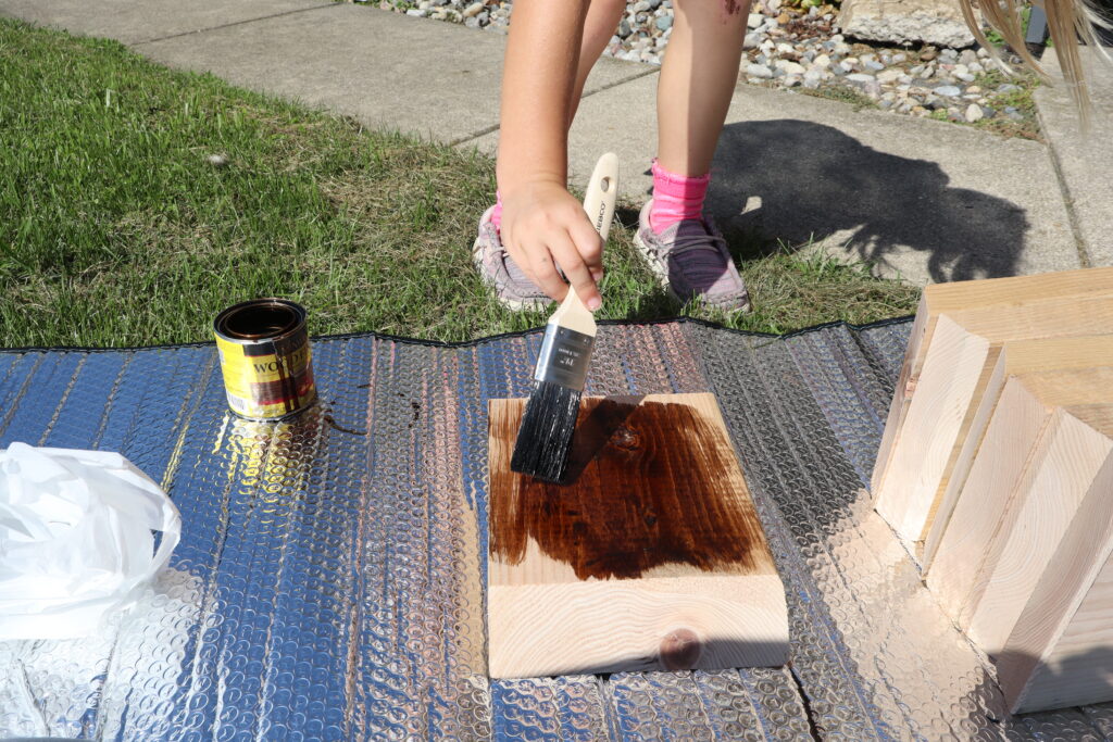 Painting wood stain on the cut wood.